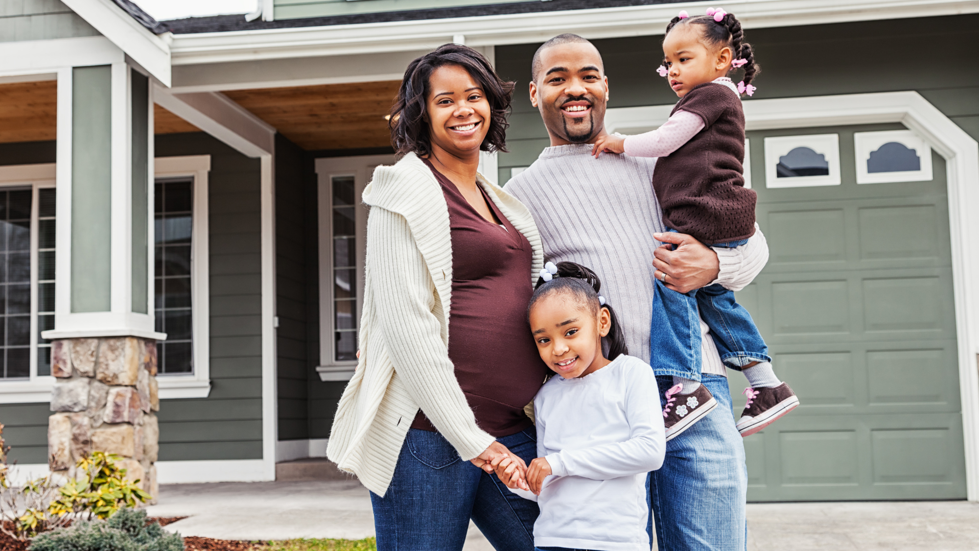 happy family in front of home 