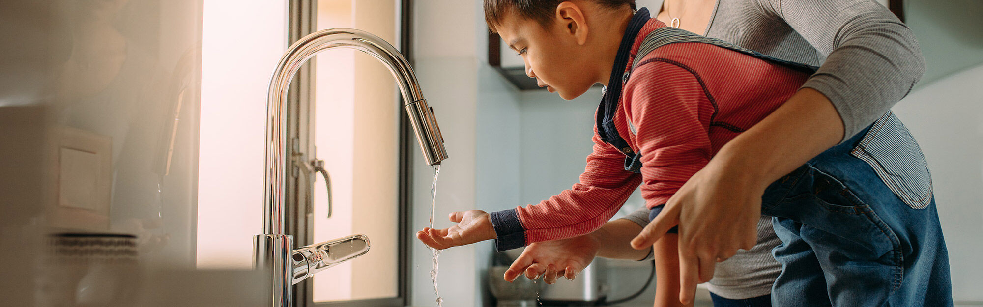 Family smiling at sink